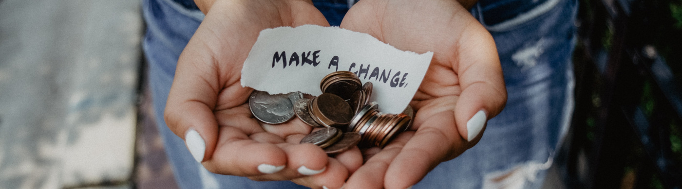 hands holding coins and note that says make a change